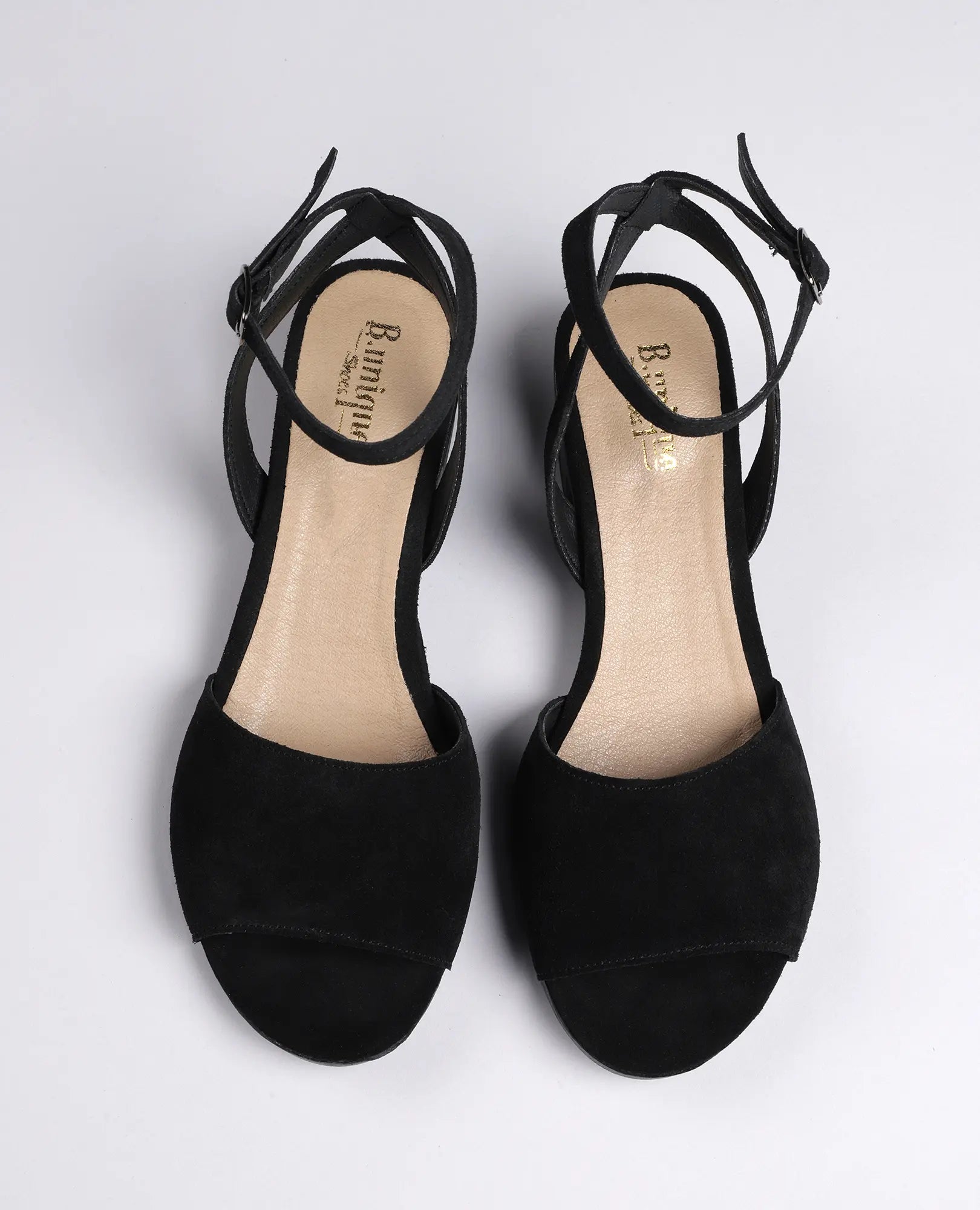 סנדלי פלה מזמש - סנואו לנשים מבית B.unique, בצבע שחור עם רצועת קרסול ועקב נמוך, עם אצבעות חשופות.