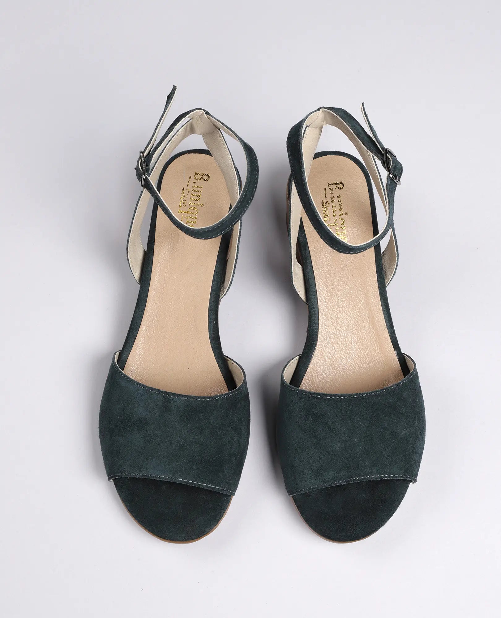 סנדלי פלה זמש-סנואו לנשים מבית B.unique עם רצועות קרסול, מצולמים מלמעלה על רקע לבן.