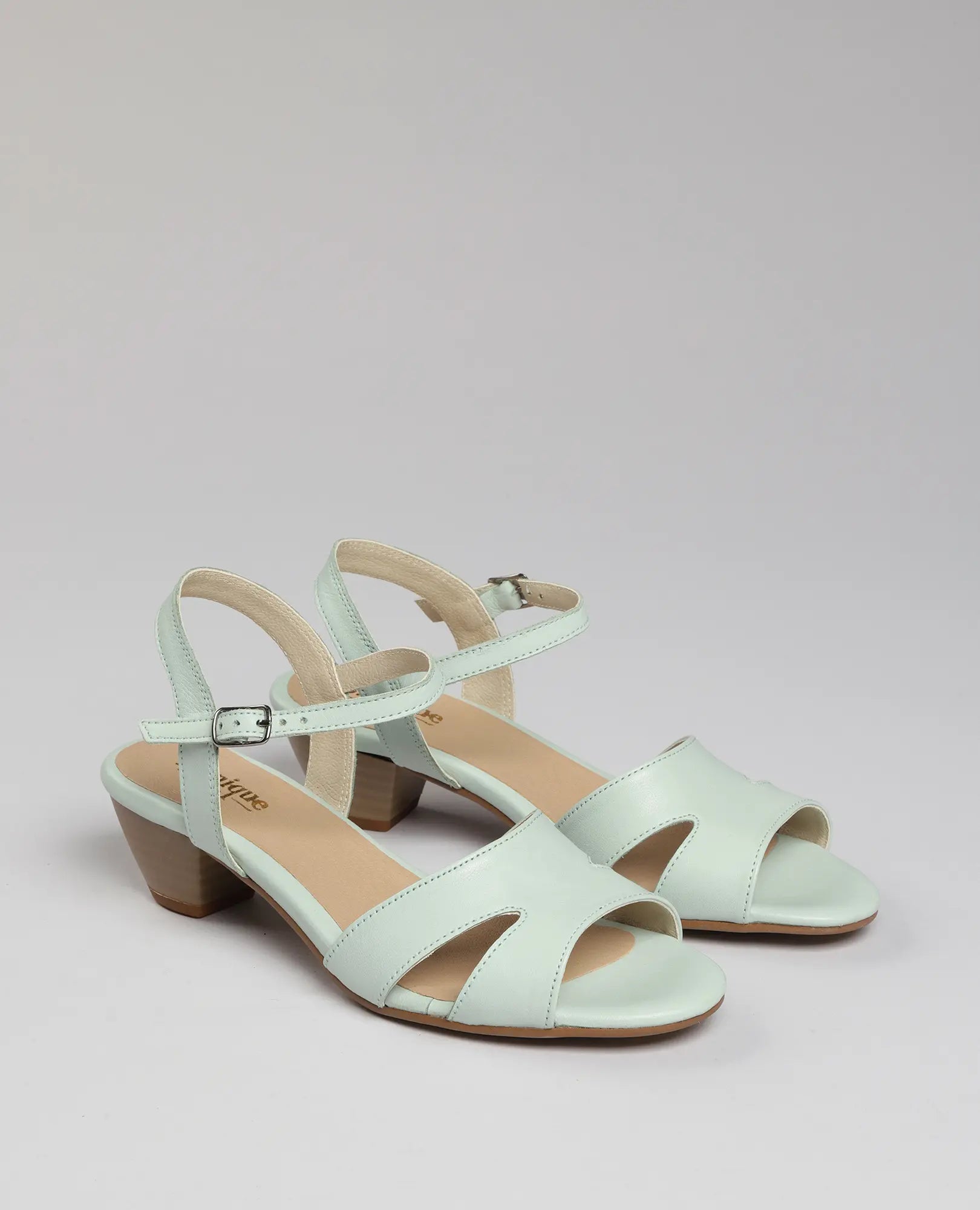 סנדלי עקב "פלורנס" בצבע מנטה מעור איכותי עם רצועות קרסול מבית B.unique, מוצגים על רקע ניטרלי.