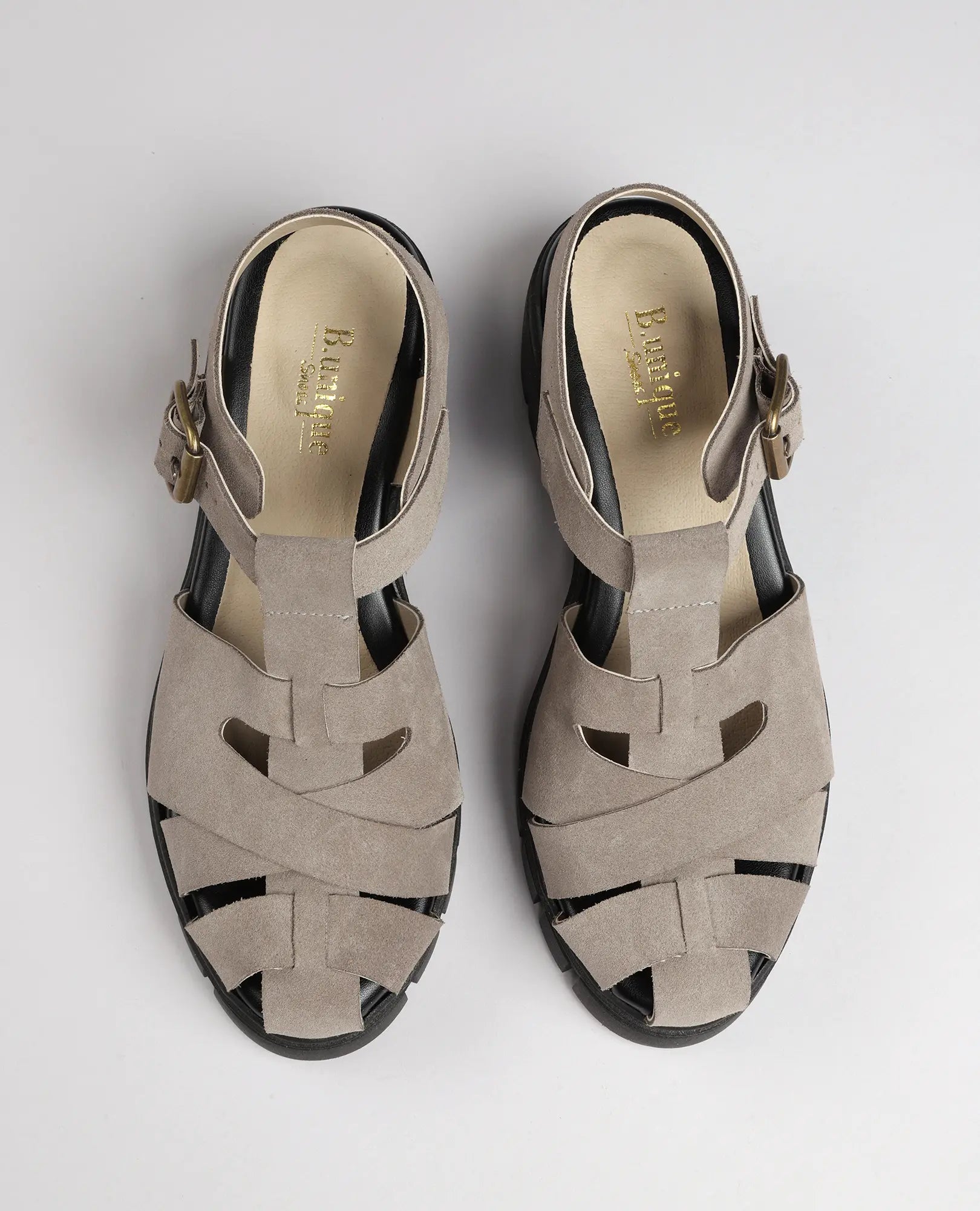 זוג סנדלי גלדיאטור "אינס" של B.unique בעיצוב קלוע וברצועות בקרסול, מצולמים מלמעלה על רקע לבן.