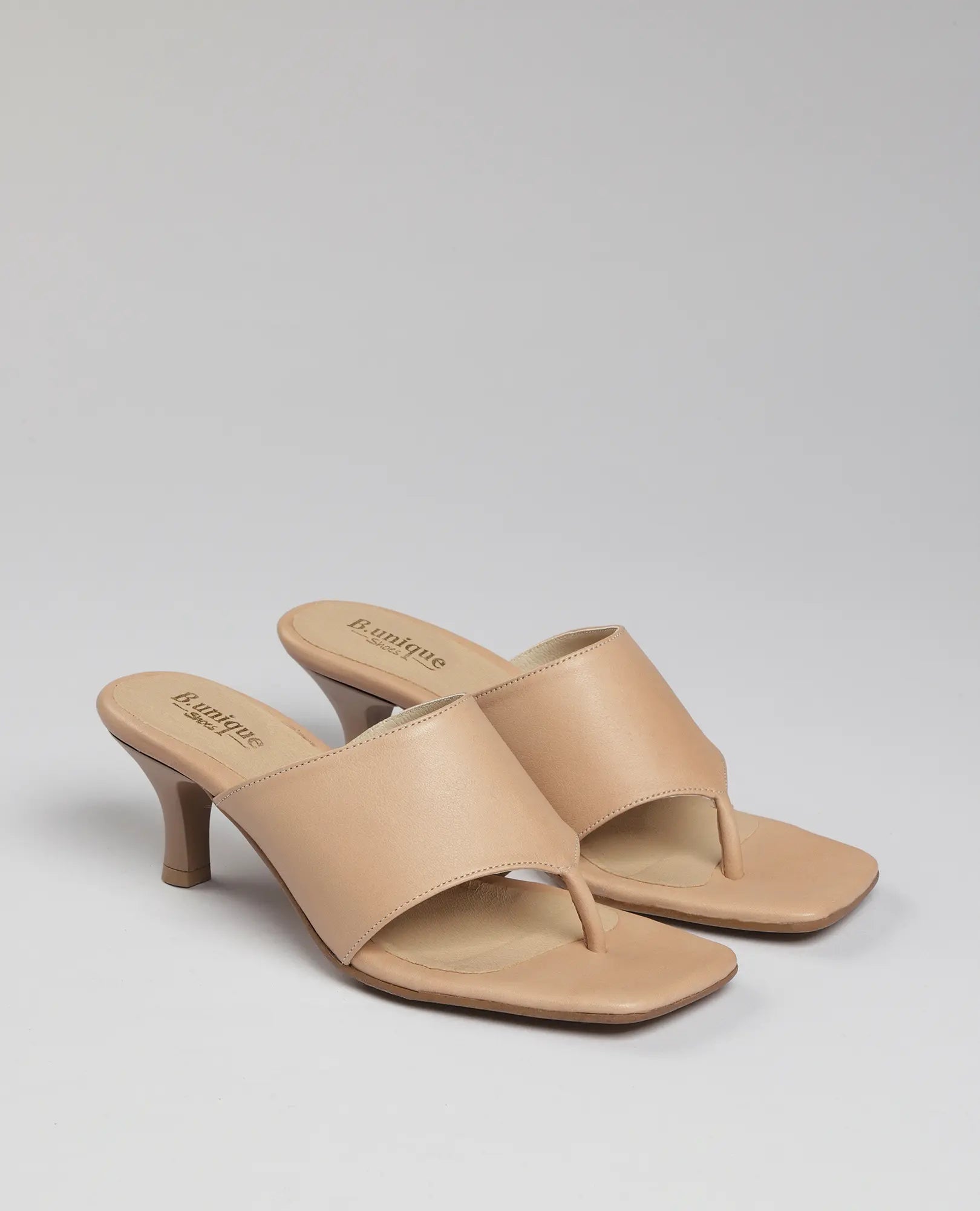 כפכפי אצבע עם עקב של המותג B.unique בצבע ניוד, עם רצועות רחבות ועקב בינוני, בעיצוב עם קצה מרובע.