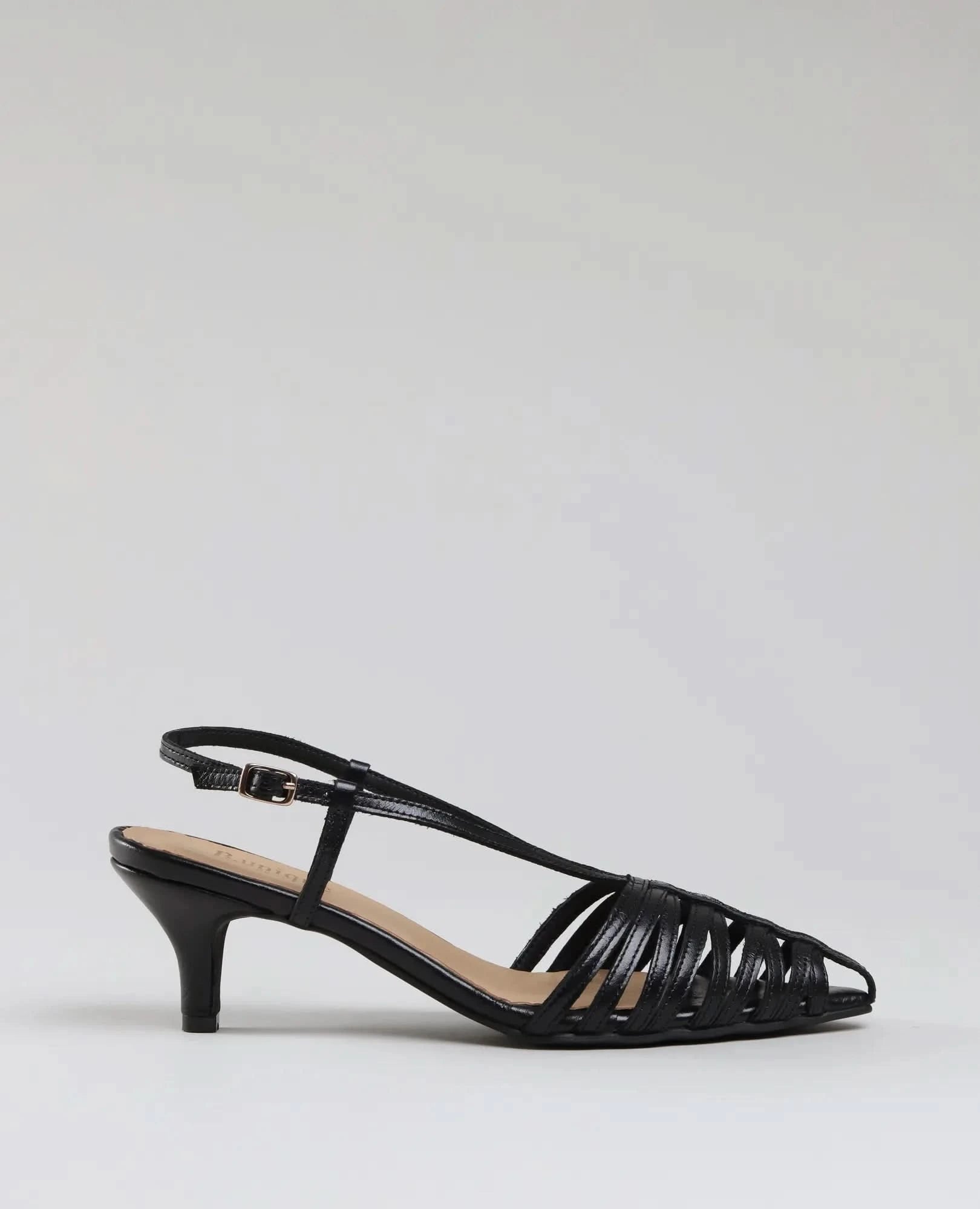 The סנדלי עקב- מיכאלה is a black strappy heeled sandal with an ankle strap and low kitten heel, shown in profile against a light grey background—ideal for any occasion.