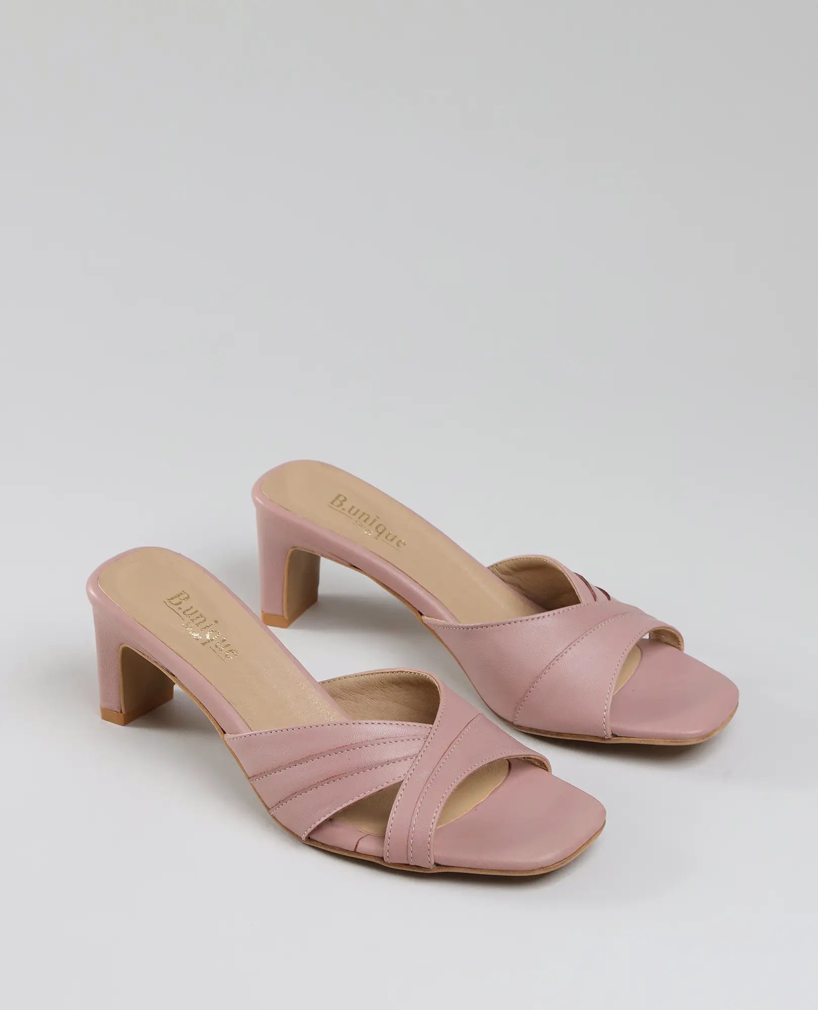 B.unique כפכפי עקב – ורודים-ארגמן עם רצועות מוצלבות ועקב בינוני, מוצגים על רקע לבן.