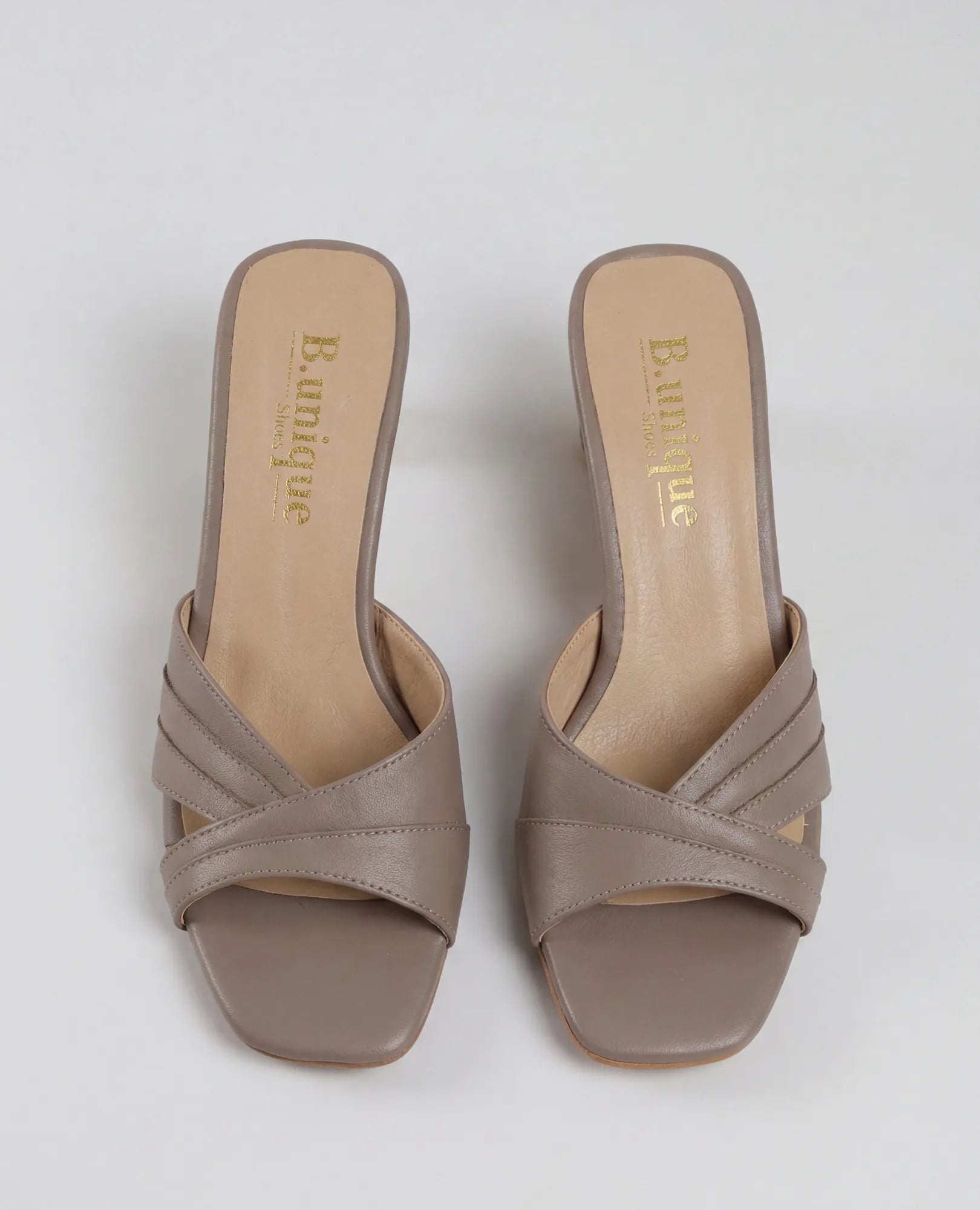 כפכפי עקב של B.unique בצבע ארגמן, עם רצועות מצטלבות ועשויים מעור איכותי.