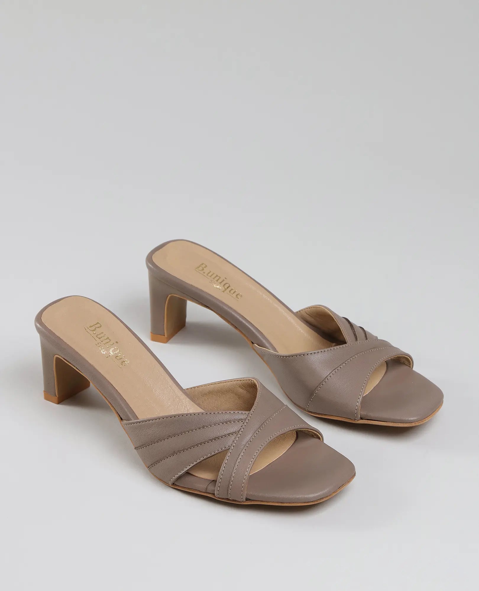 כפכפי עקב בצבע ארגמן מבית B.unique, מעור איכותי בצבע טאופה, עם רצועות מצטלבות ועקב בינוני.