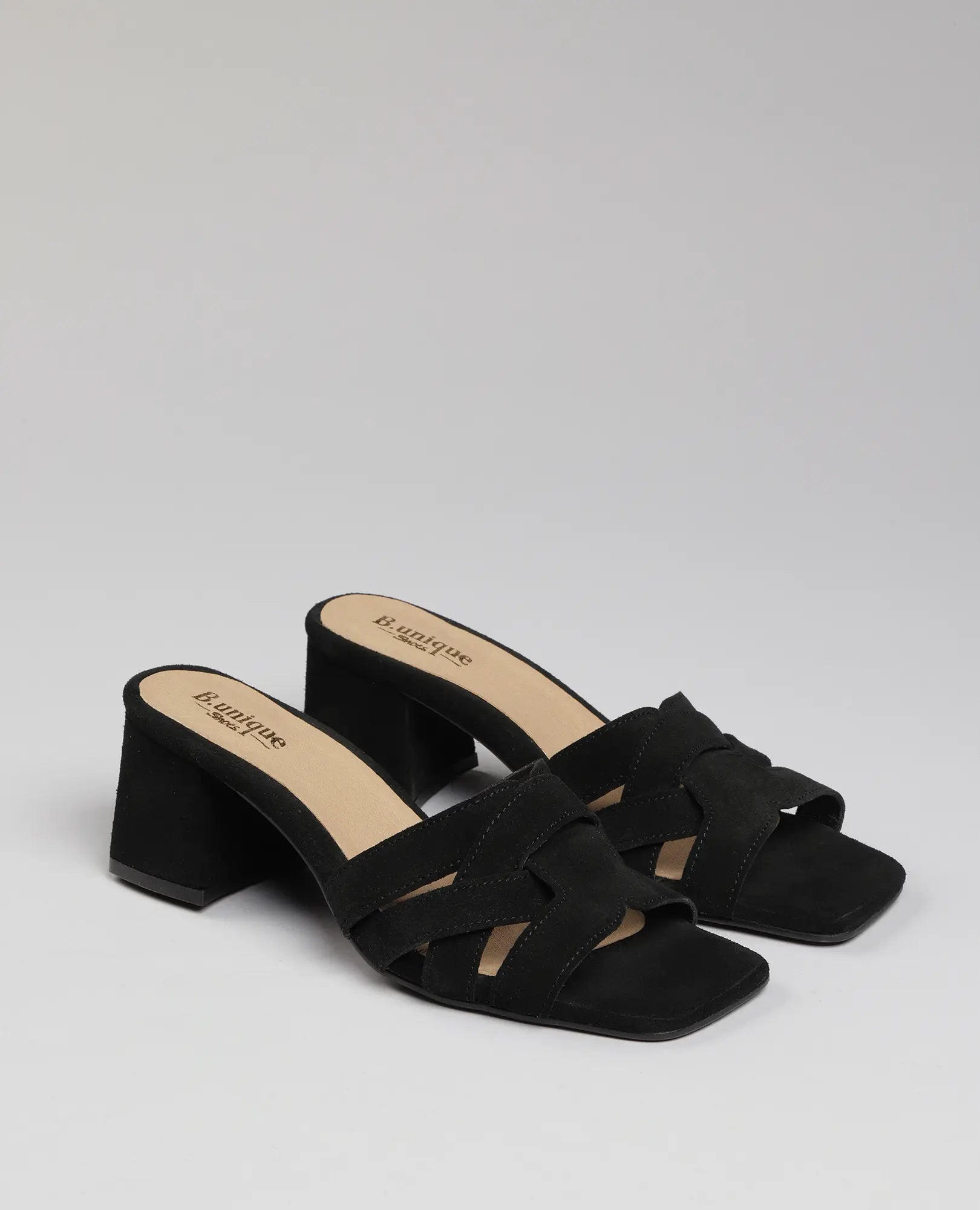 B.unique כפכפי עקב-מרגי שחורים מעור זמש עם רצועות מוצלבות ועקב רחב, דגם עם אצבעות חשופות, רקע חלק.