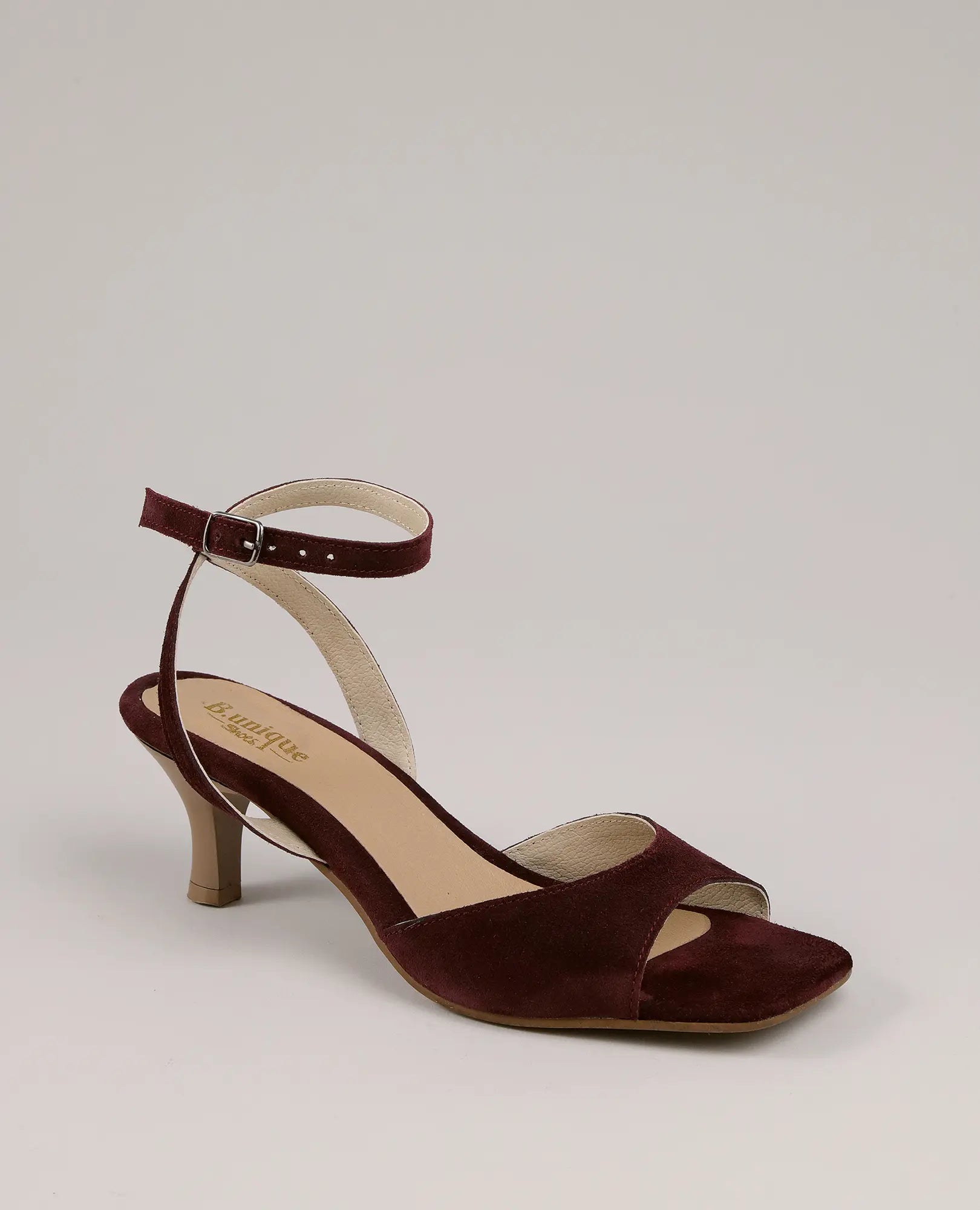 סנדלי עקב - נייה מבית B.unique, בעיצוב זמש בורדו עם רצועת קרסול ועקב נמוך, מוצגים על רקע ניטרלי.
