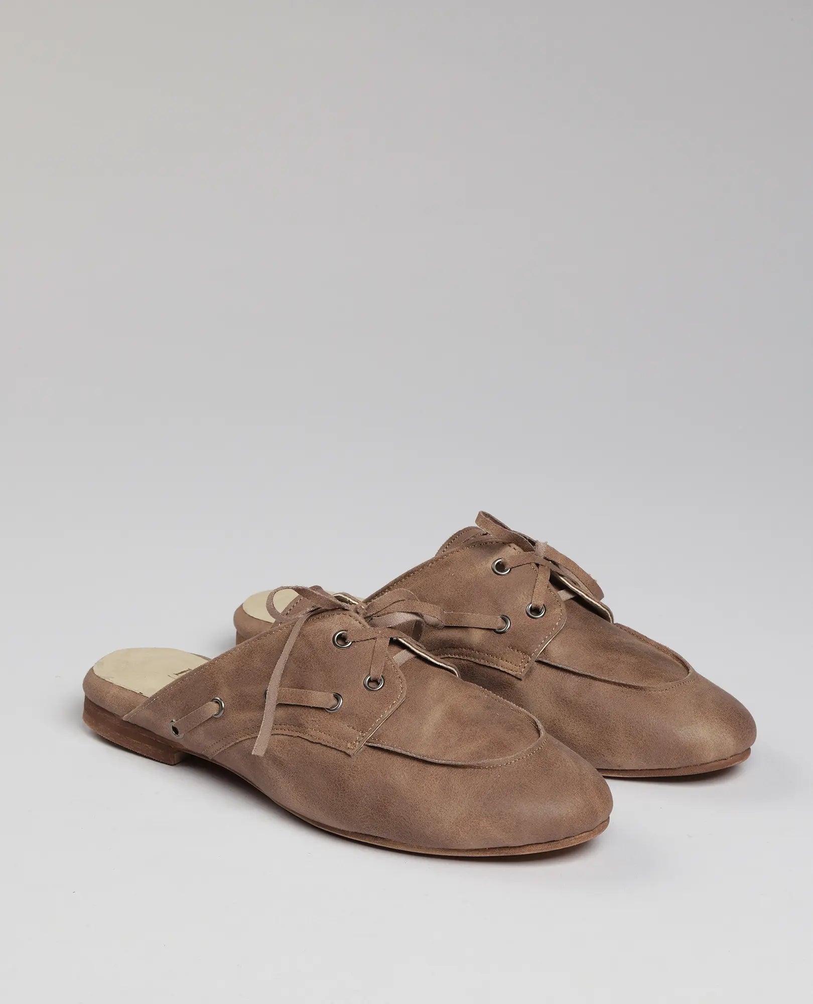 כפכפי מוקסין-לירי של B-Unique VEGAN: דמוי עור חום, גב פתוח, שרוכים ועקב נמוך, על רקע בהיר.