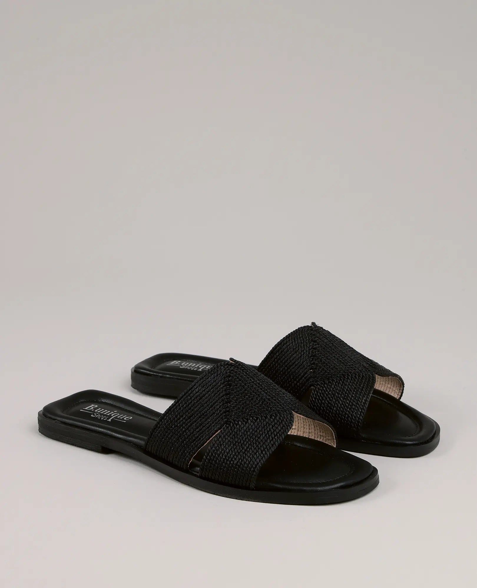 זוג כפכפי רקמה - אלירן מבית B-Unique VEGAN עם רצועות רחבות ארוגות בשחור ואצבעות פתוחות, על רקע בהיר.