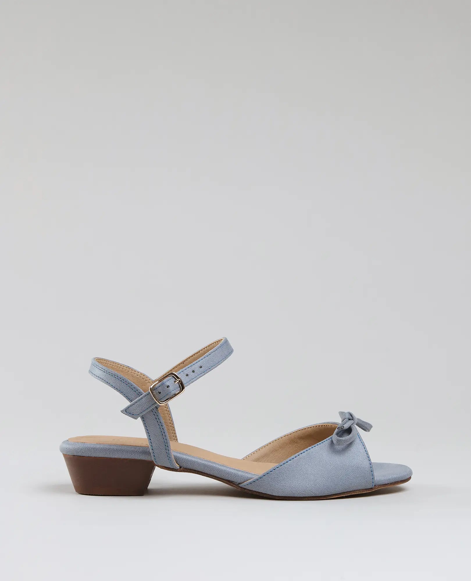 סנדלי פפיון קשורים - קלאודיה מבית B-Unique VEGAN, דמוי עור בצבע תכלת עם עקב בלוק ורצועה סביב הקרסול.
