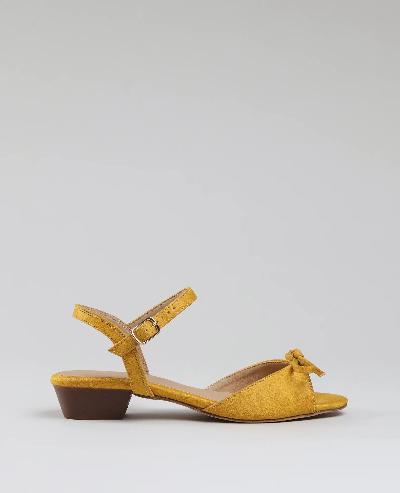 B-Unique VEGAN סנדלי פפיון קשורים - קלאודיה: סנדלים צהובים עם עקב נמוך, רצועת קרסול ופפיון על רקע חלק.