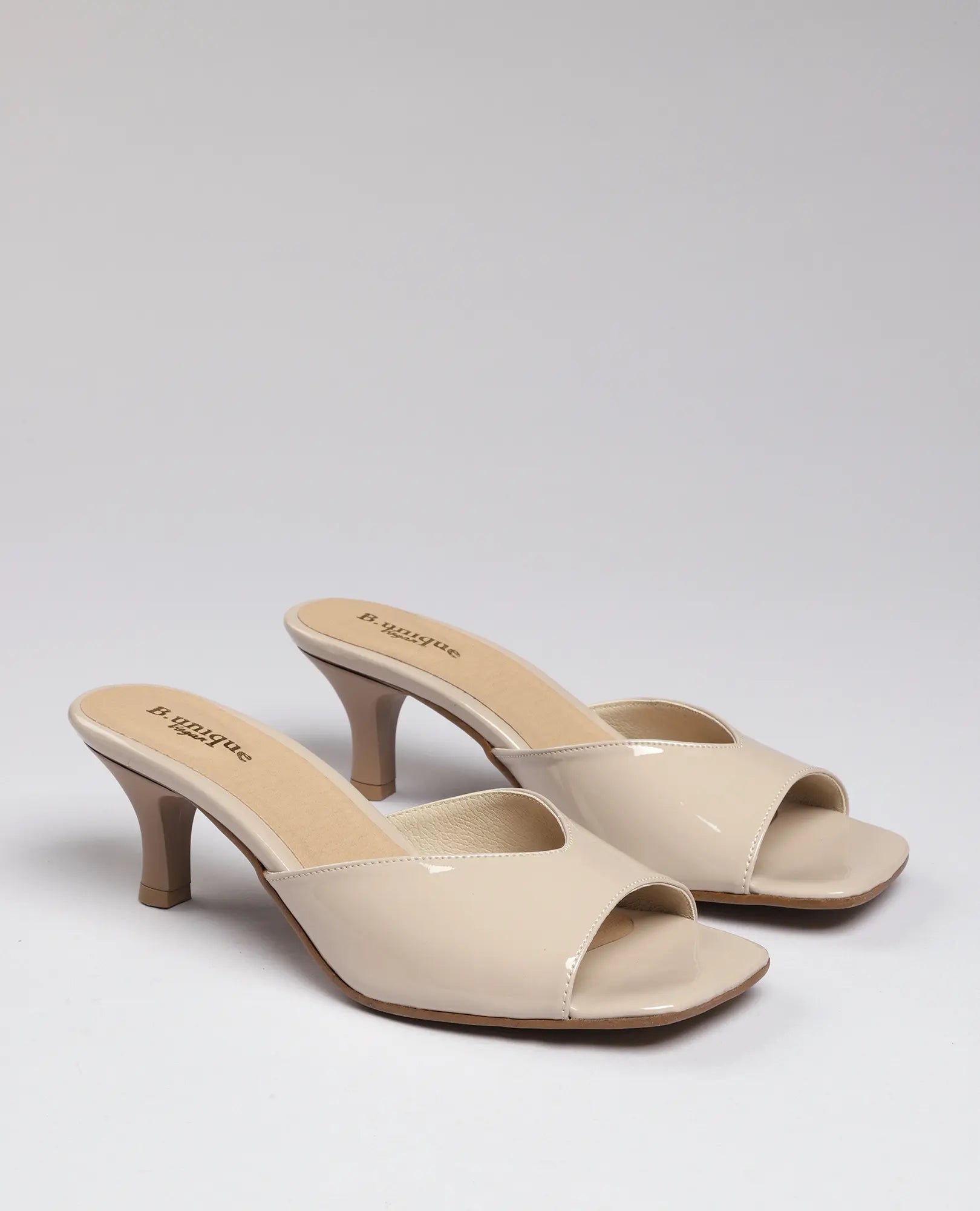 כפכפי עקב מבית B-Unique VEGAN, דמוי עור בגוון בז', עם עקב בינוני וגימור מבריק.