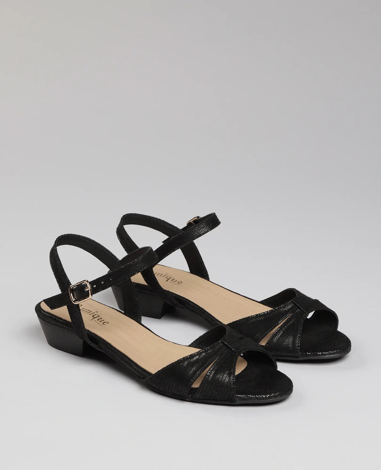 סנדלי רצועות בסגנון לוקי בצבע שחור מבית B-Unique VEGAN, עם עקב נמוך ורצועות קרסול, על רקע בהיר.