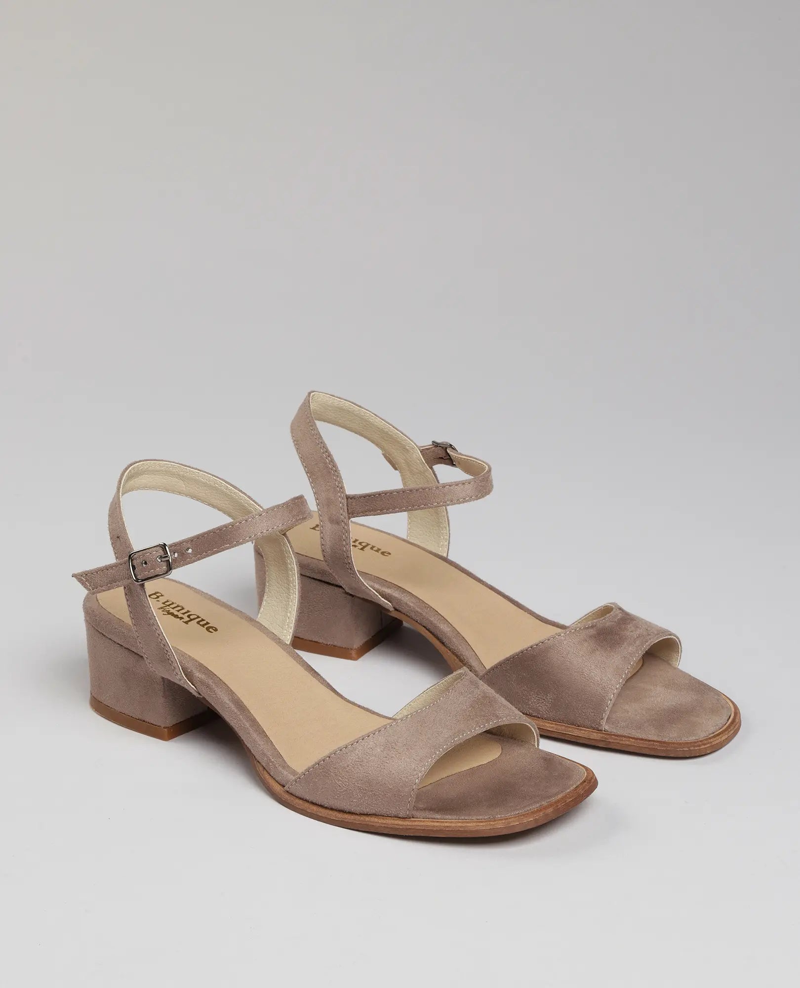 סנדלי עקב בצבע טאופ של B-Unique VEGAN, עם רצועת קרסול ועקב בינוני, מוצגים על רקע בהיר.