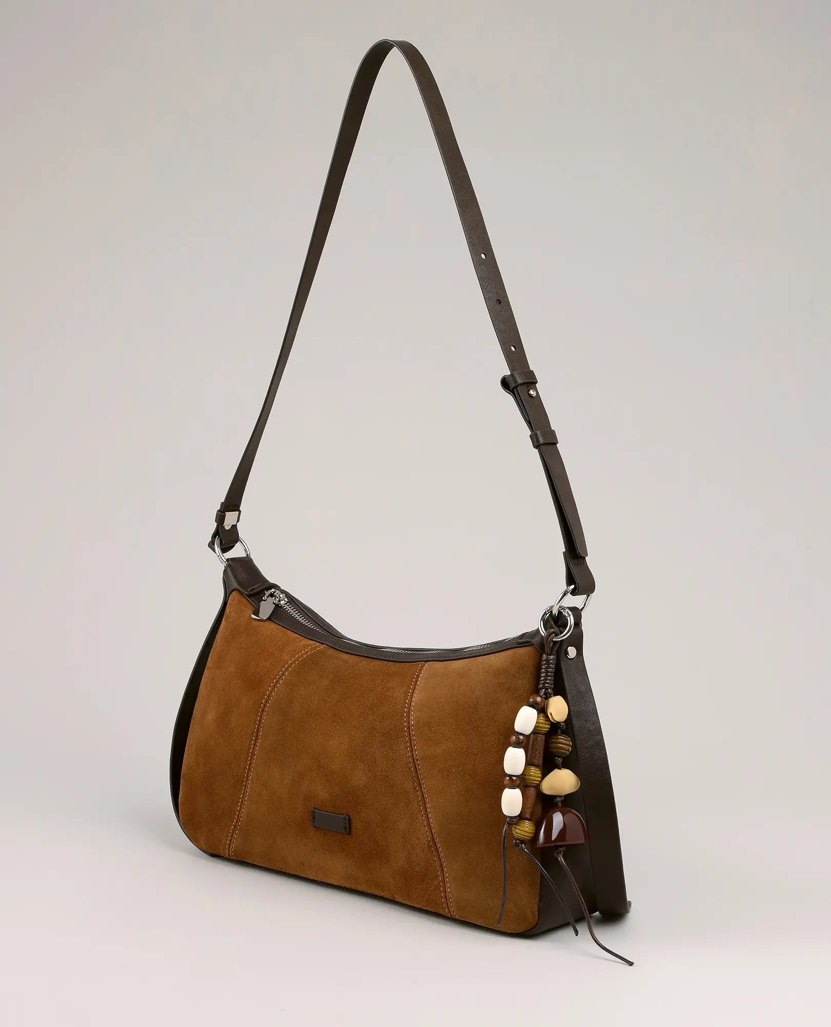 תיק צד מעור זמש-נואל מבית B-Unique Bags עם רצועה ארוכה וקישוט חרוזים, מוצג על רקע חלק.