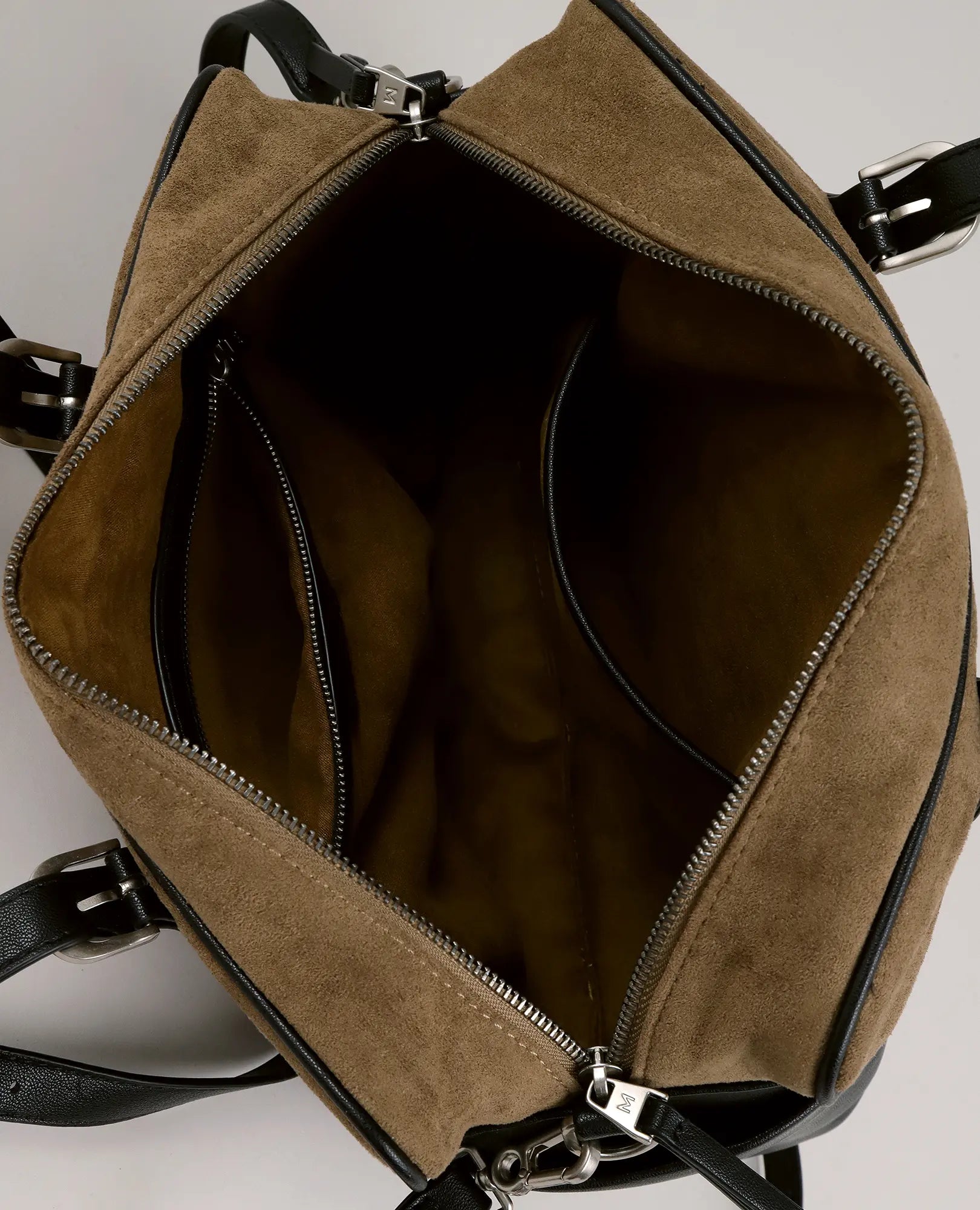 תיק הצד "מנדי" מבית B-Unique Bags הוא תיק מעור סינתטי חום עם רצועות שחורות, חלל פנימי מרווח ושני תאים עם רוכסן.