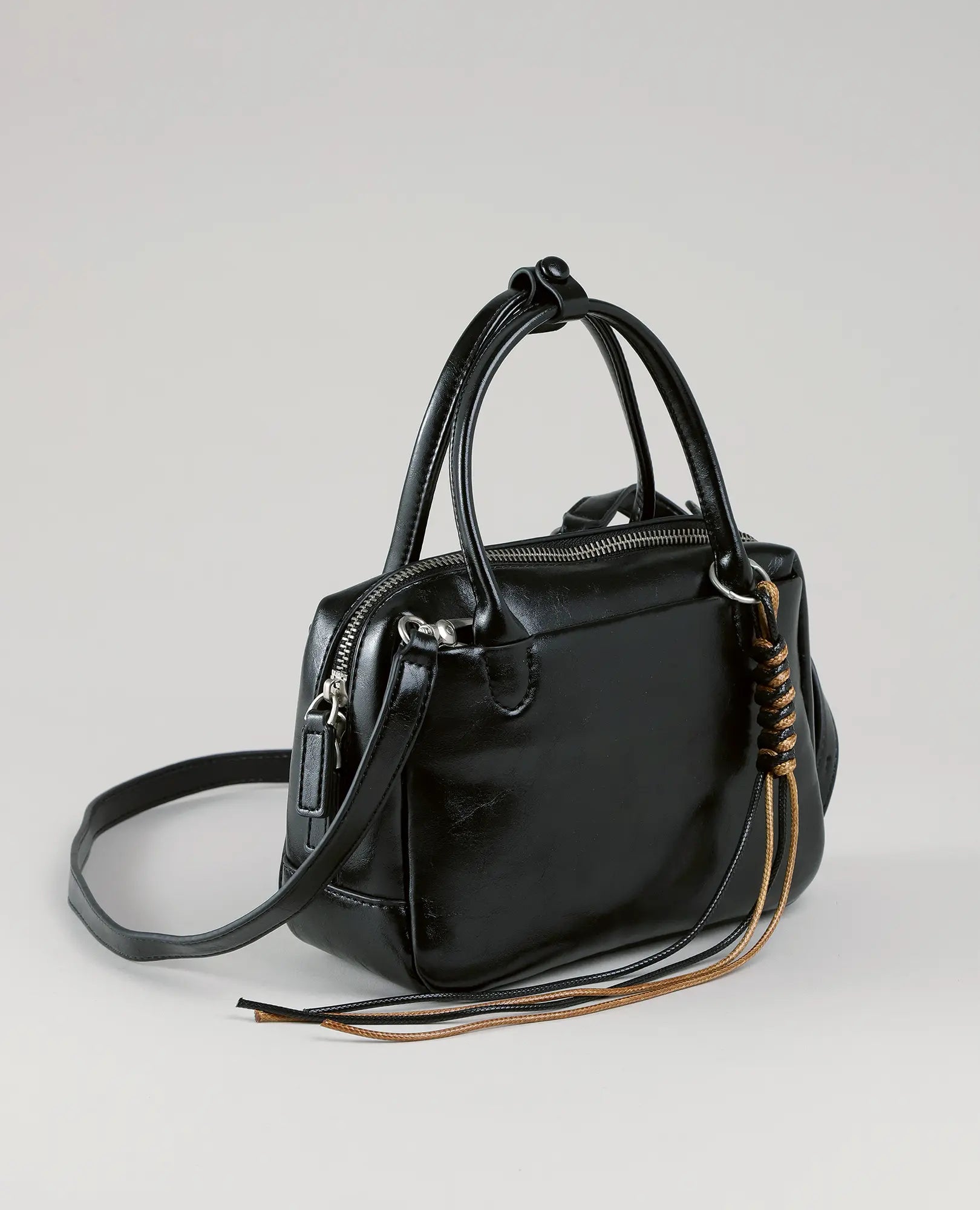 תיק צד מיני מזוודה-וינה מבית B-Unique Bags בצבע שחור, עם שתי ידיות, רצועת כתף ורוכסן עליון.