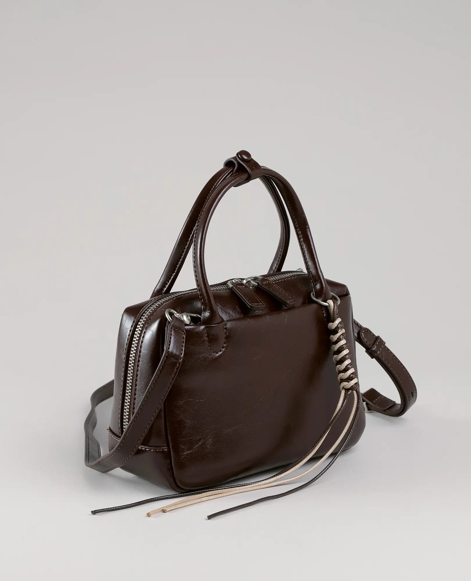תיק צד מיני דמוי מזוודה בסגנון וינאי מבית B-Unique Bags, מעור דמוי עור חום כהה עם ידיות, רוכסן ורצועת כתף.