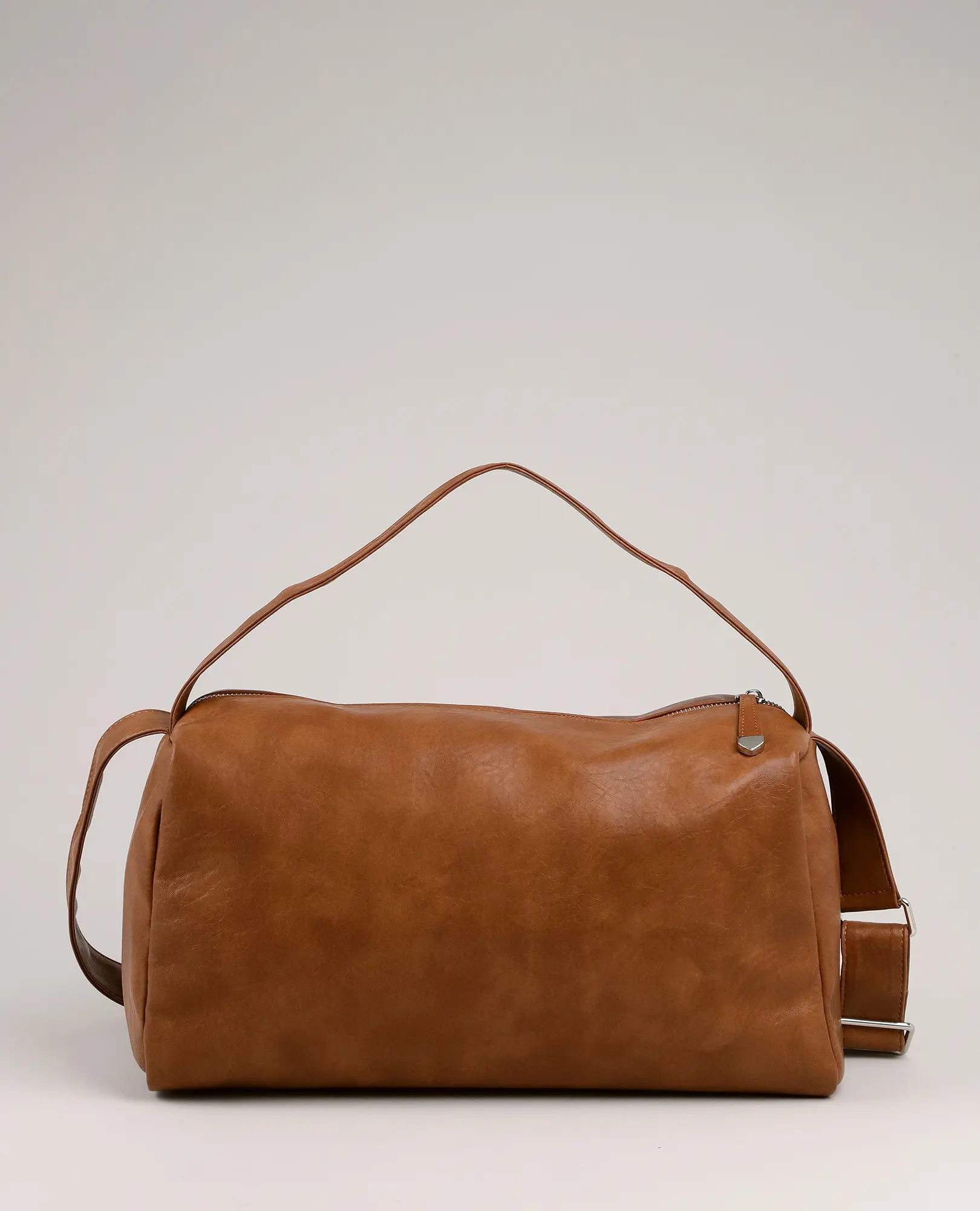 תיק צד רך בצבע חום מדגם "ונסה" מבית B-Unique Bags, עם ידית עליונה ורצועה מתכווננת, על רקע אפור בהיר.