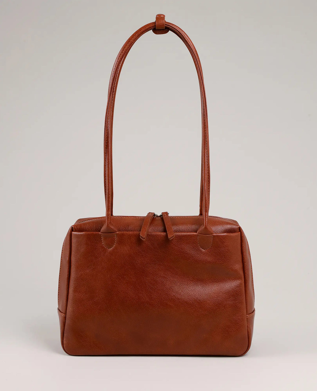 B-Unique Bags תיק צד קדמי, מעור חום עם שתי ידיות ארוכות, מעוטר באיור של נעלי נשים על רקע אפור בהיר.