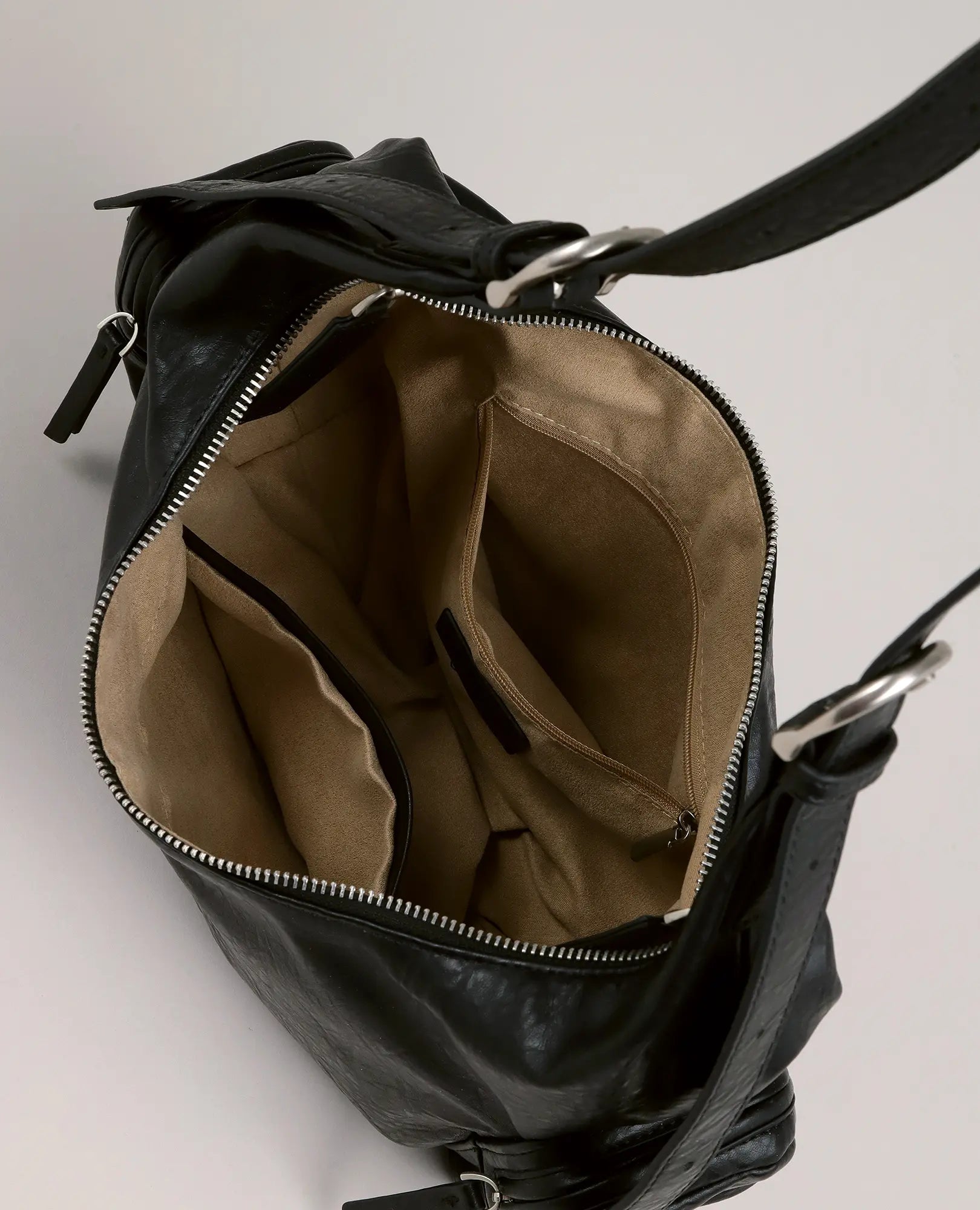 תיק צד "דור" מבית B-Unique Bags עם בטנה בצבע בז' וכיסים רבים, במבט מלמעלה על משטח בהיר.