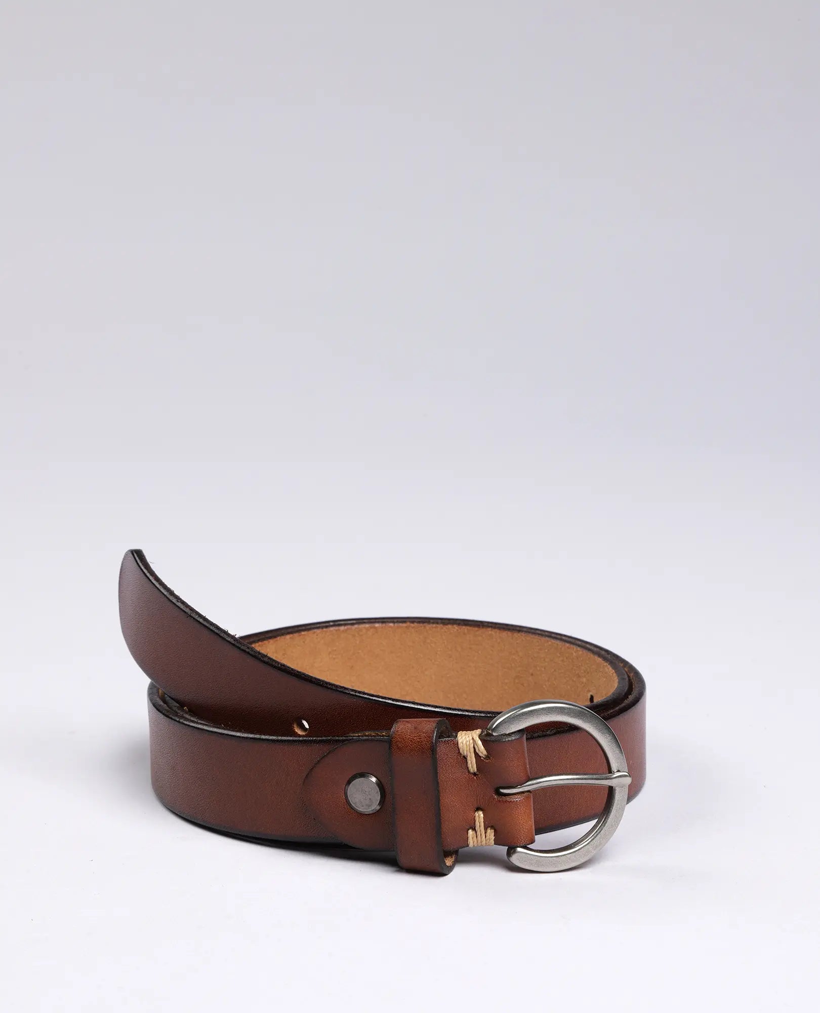 חגורת עור עם אבזם עגול-דקורטיבי של B Unique בגוון חום עם אבזם כסף, מוצגת על רקע לבן.