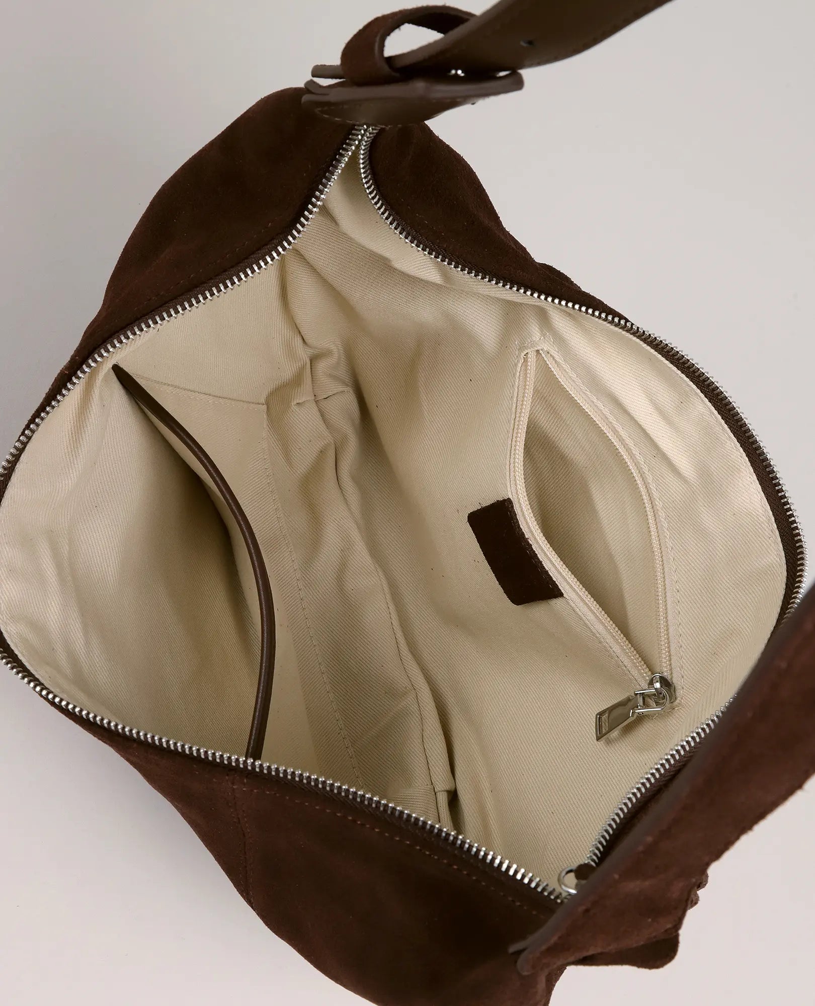 תיק פאוץ 'ירח - עינב מבית B-Unique Bags, עשוי זמש חום עם בטנה בצבע בז' וכיס פנימי גלוי עם רוכסן.