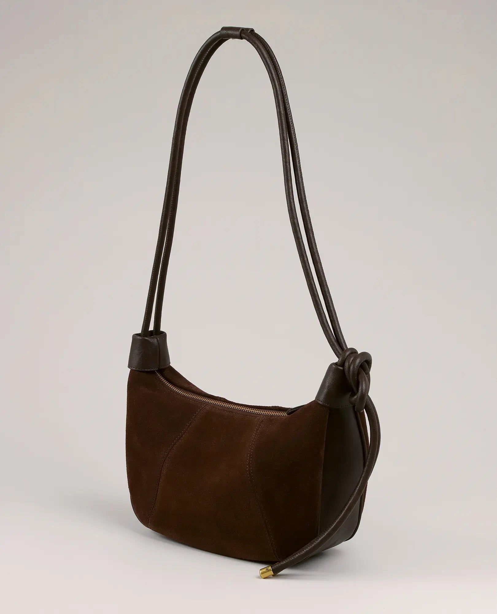 תיק צד "בלייר" מבית B-Unique Bags מעור זמש חום כהה, עם רצועות כפולות וקשר דקורטיבי.