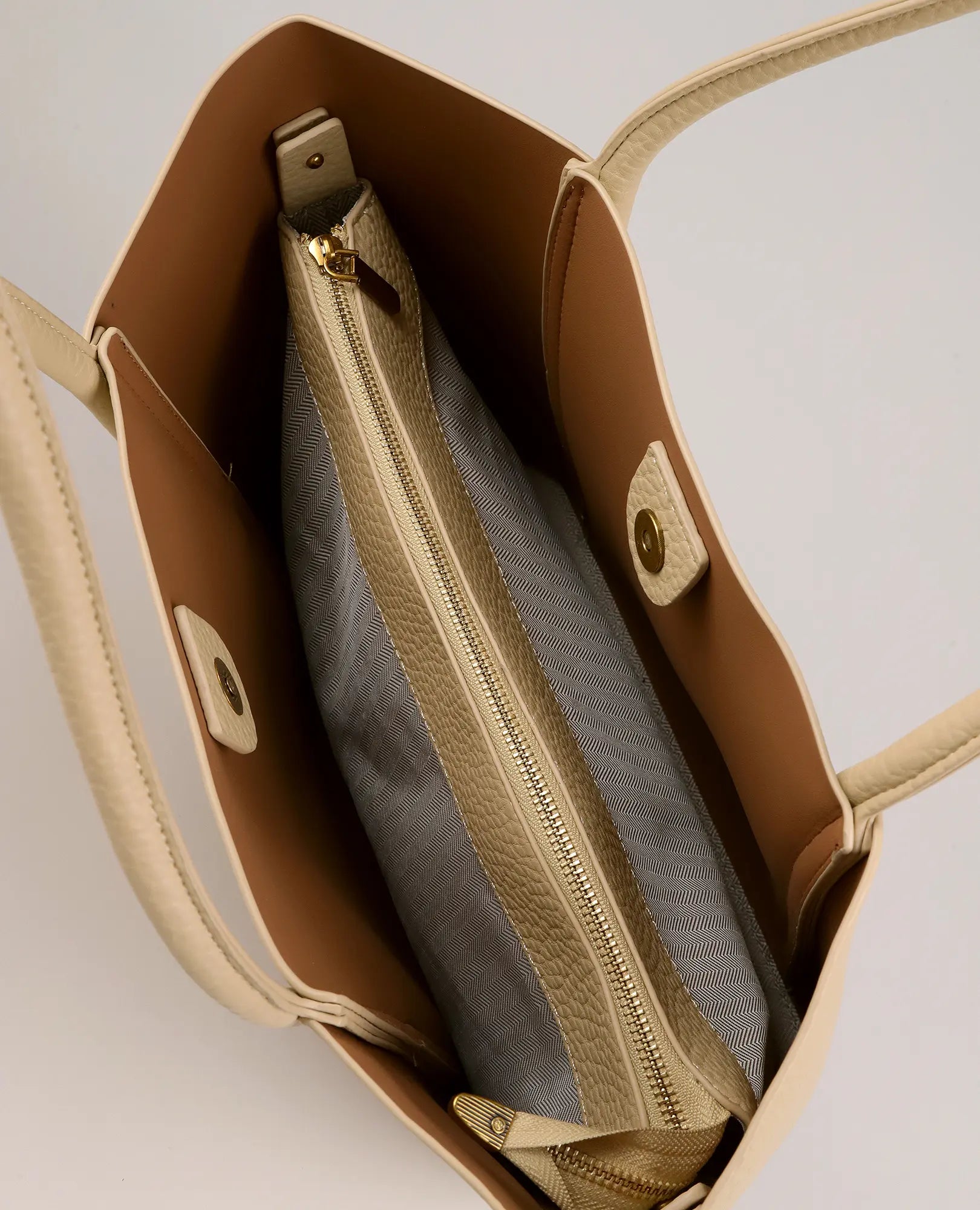 מבט מלמעלה על תיק הצד "ליבי" של B-Unique Bags בצבע בז', עם כיס אפור עם רוכסן וסגירות מגנטיות בפנים.