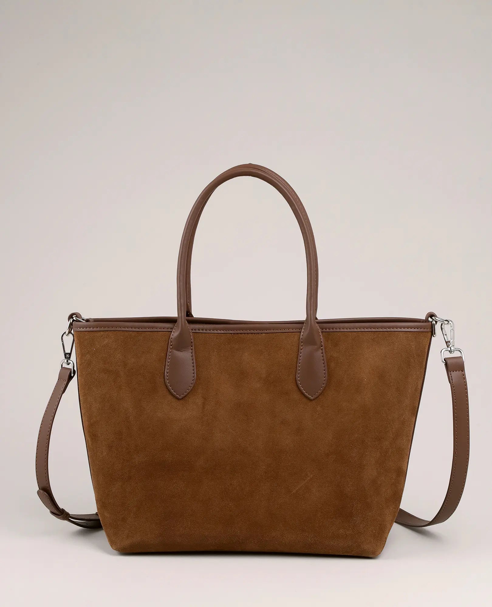 תיק צד מעור זמש בצבע חום מבית B-Unique Bags, עם שתי ידיות ורצועה נשלפת, מוצג על רקע בצבע בז' בהיר.