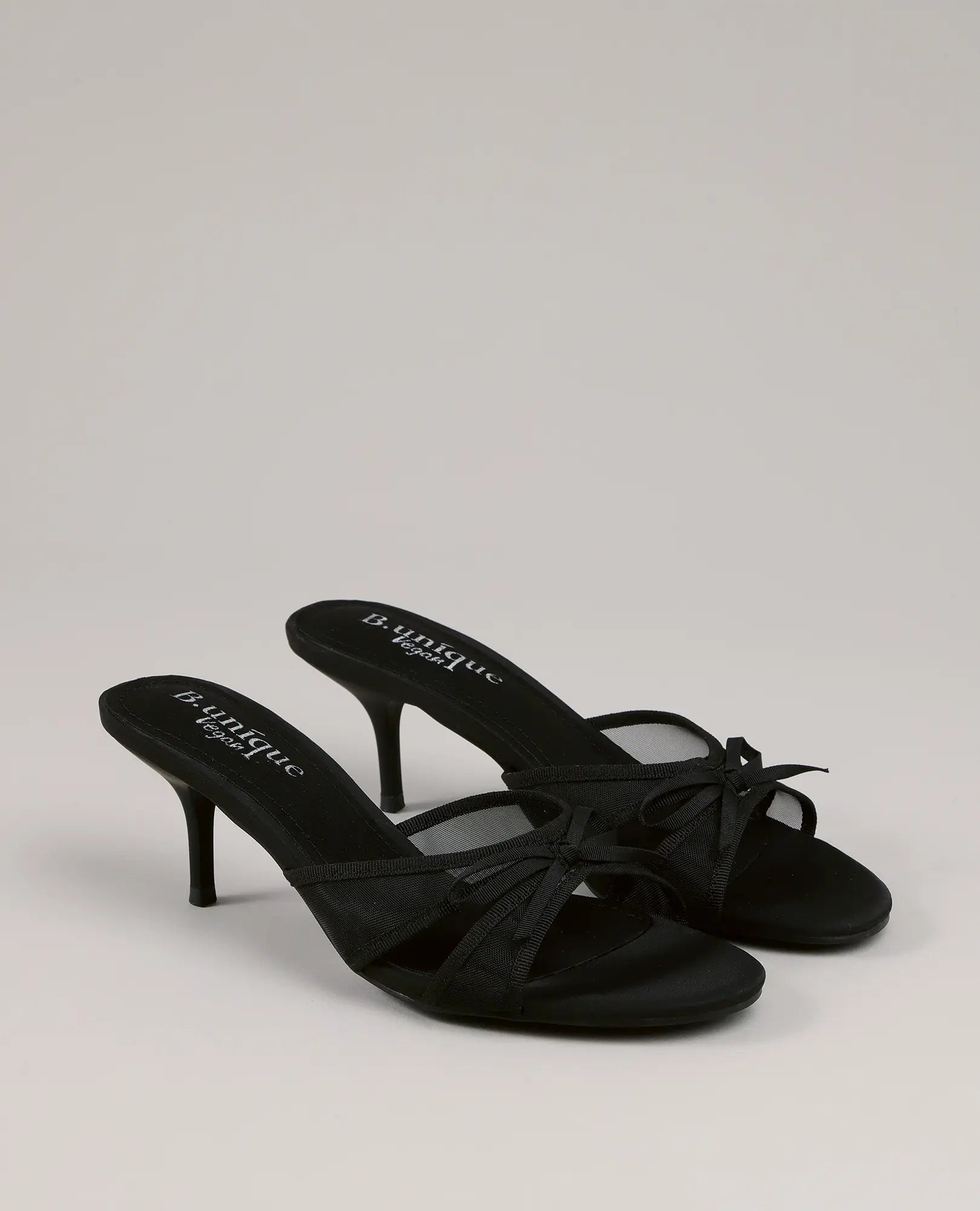 כפכפי עקב - דגם "פאר" של B-Unique VEGAN: כפכפים שחורים עם עקב דק, רצועות מצטלבות ופפיון קדמי.