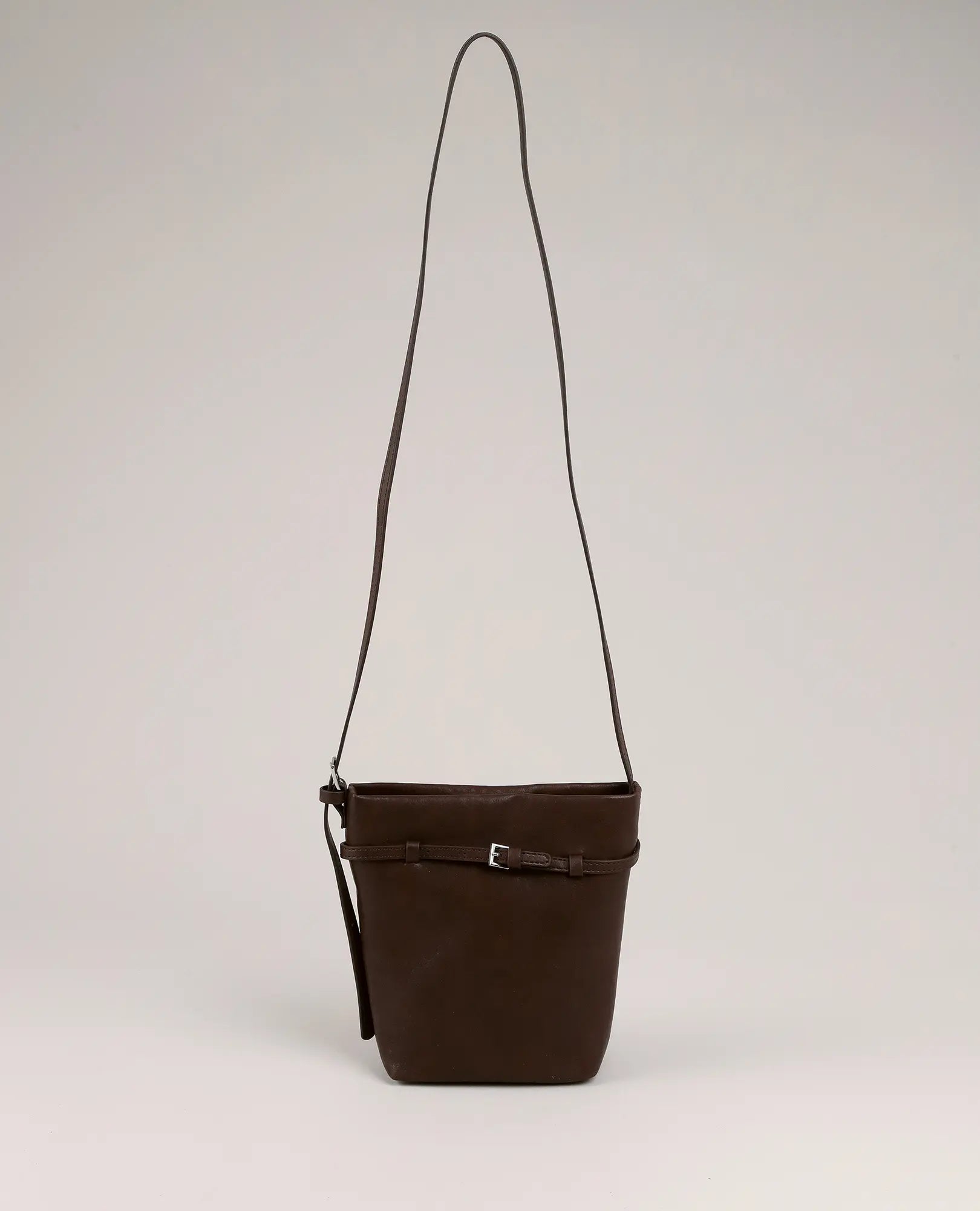 תיק צד-חן של B-Unique Bags דמוי עור חום עם רצועה ארוכה ואבזם, מונח על רקע בהיר.