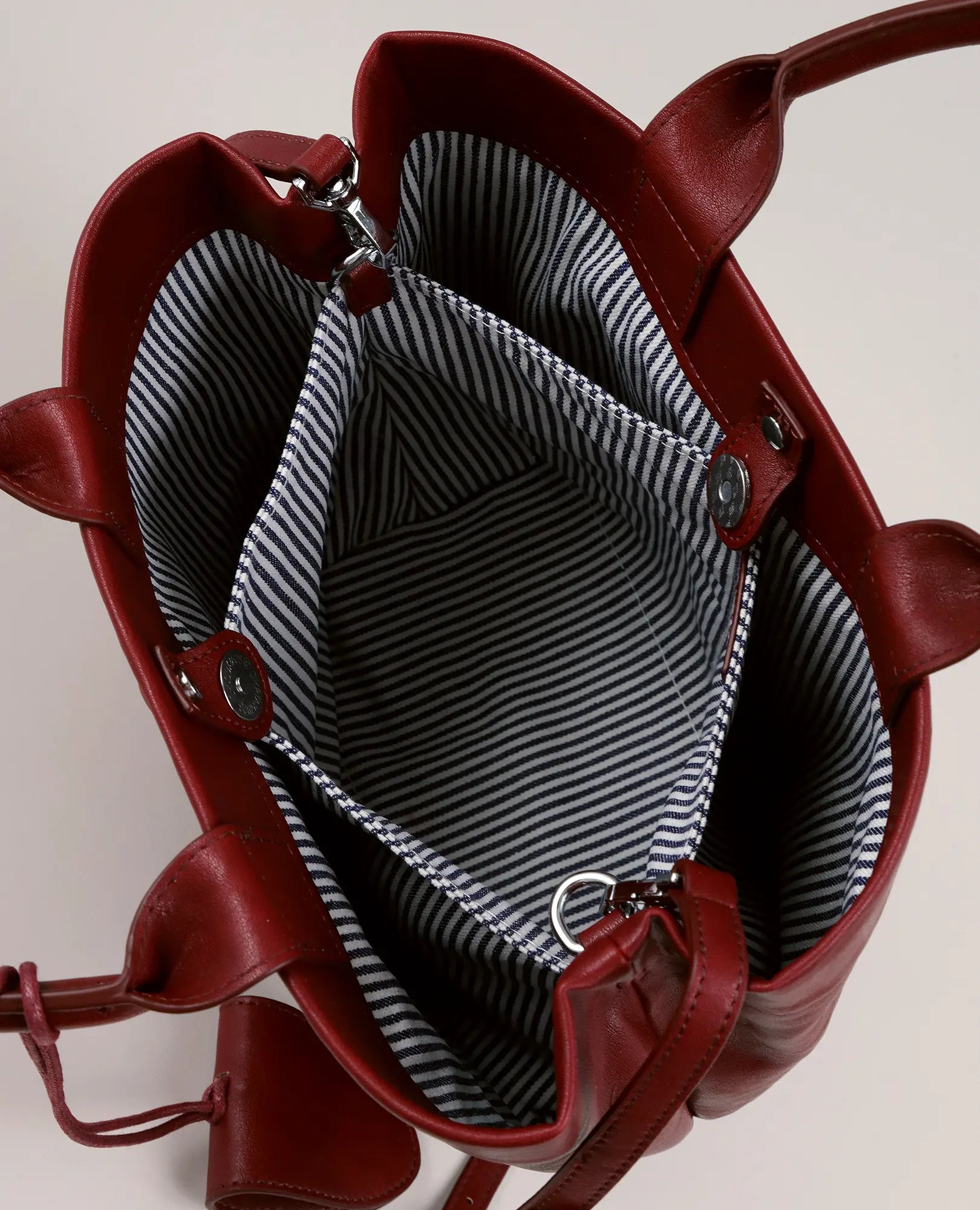 תיק צד כפלים אדום של דניאלה מבית B-Unique Bags עם בטנה מפוספסת בשחור ולבן, בתצוגה מלמעלה.