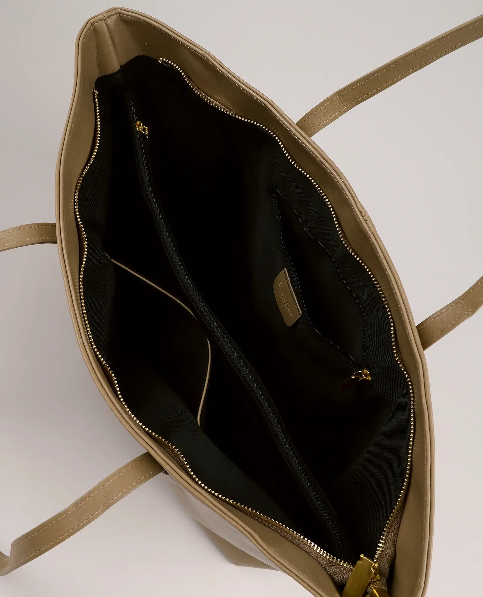 תיק צד גדול בצבע שקד מבית B-Unique Bags, מעור דמוי עור בגוון טאן, עם בטנה שחורה, שני תאים עם רוכסן וכיס פנימי פתוח.