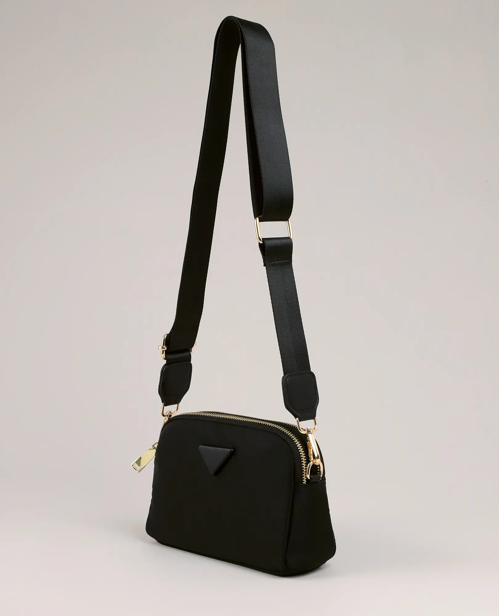 תיק צד - ויקטוריה מבית B-Unique Bags: ניילון קשיח שחור, רצועה מתכווננת, אבזמי זהב ולוגו משולש קטן.