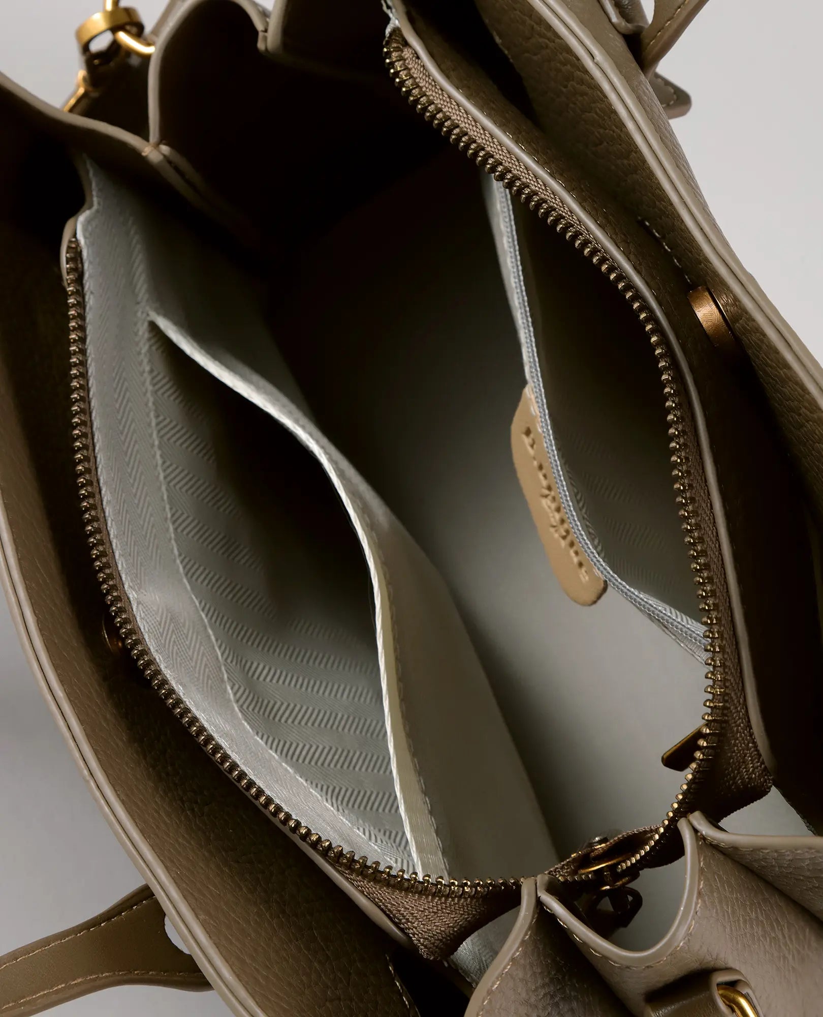 מבט מלמעלה על תיק הצד "תובל" מבית B-Unique Bags, הכולל כיסים פנימיים, מחיצה עם רוכסן, אביזרי מתכת מוזהבים ורצועת כתף.
