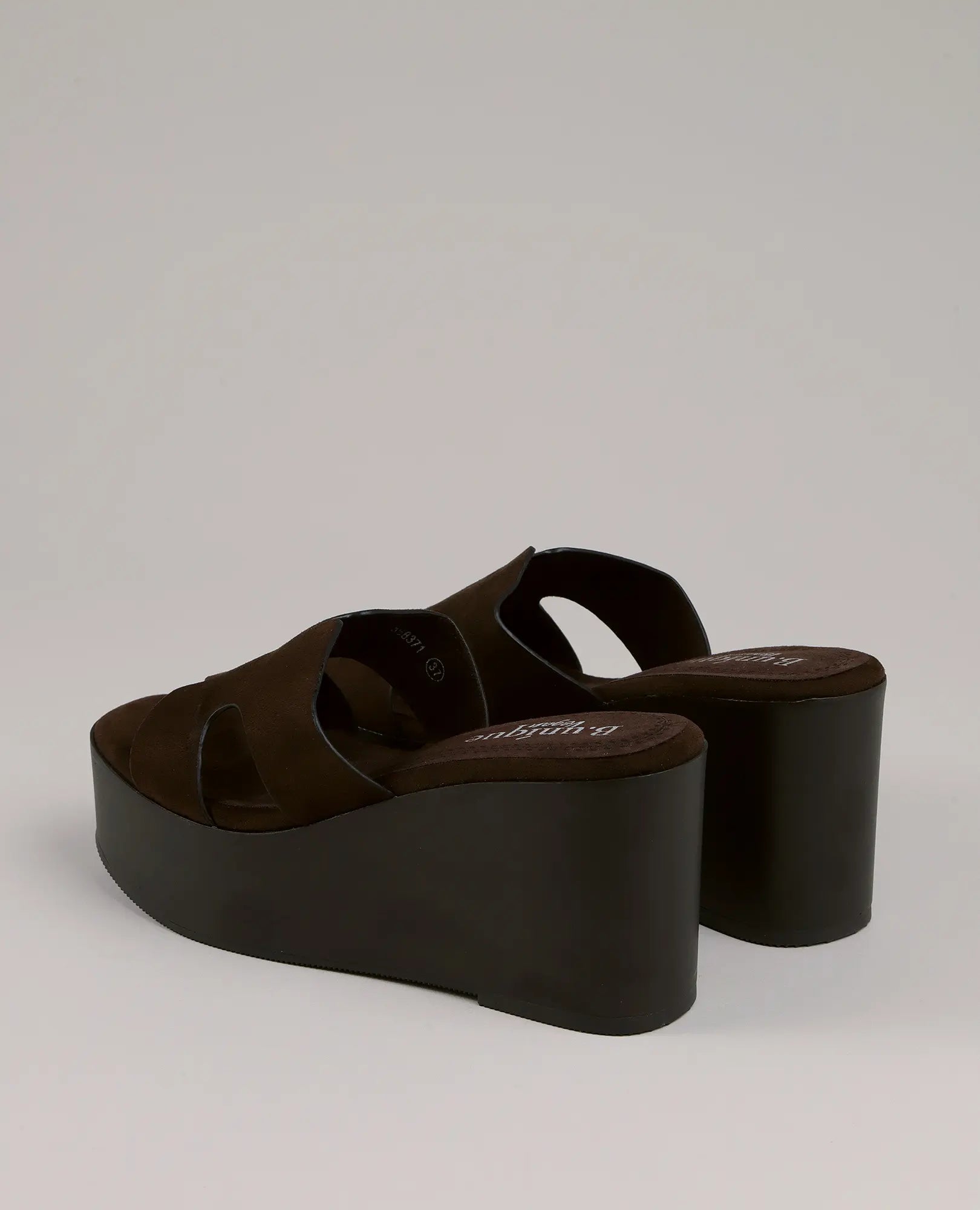 כפכפי פלטפורמה בצבע צדף של B-Unique VEGAN, דמויי עור חומים עם עקב עבה ורצועות, מוצגים על רקע בהיר.