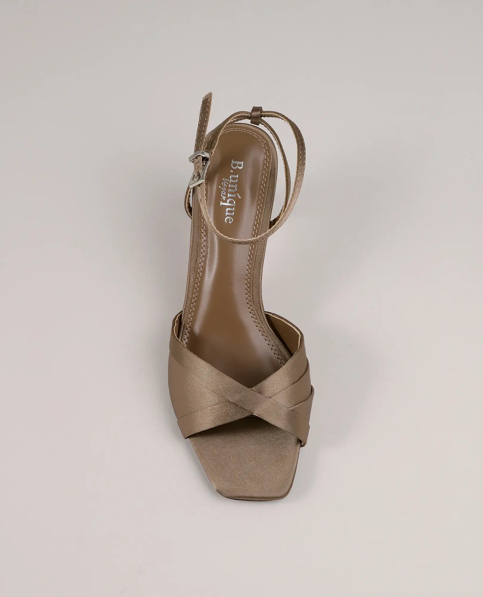 מבט מלמעלה על סנדלי סאטן עם עקב - אילאיל מבית B-Unique VEGAN בצבע טאופ, עם אצבעות חשופות, רצועות מצטלבות ואבזם בקרסול.