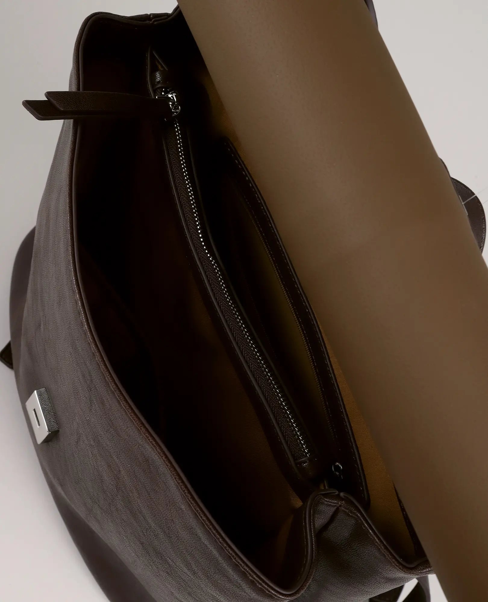 תיק גב מעור חום מדגם "נינה" מבית B-Unique Bags, עם פתח עליון פתוח, כיס פנימי עם רוכסן ומזרן מגולגל בפנים.