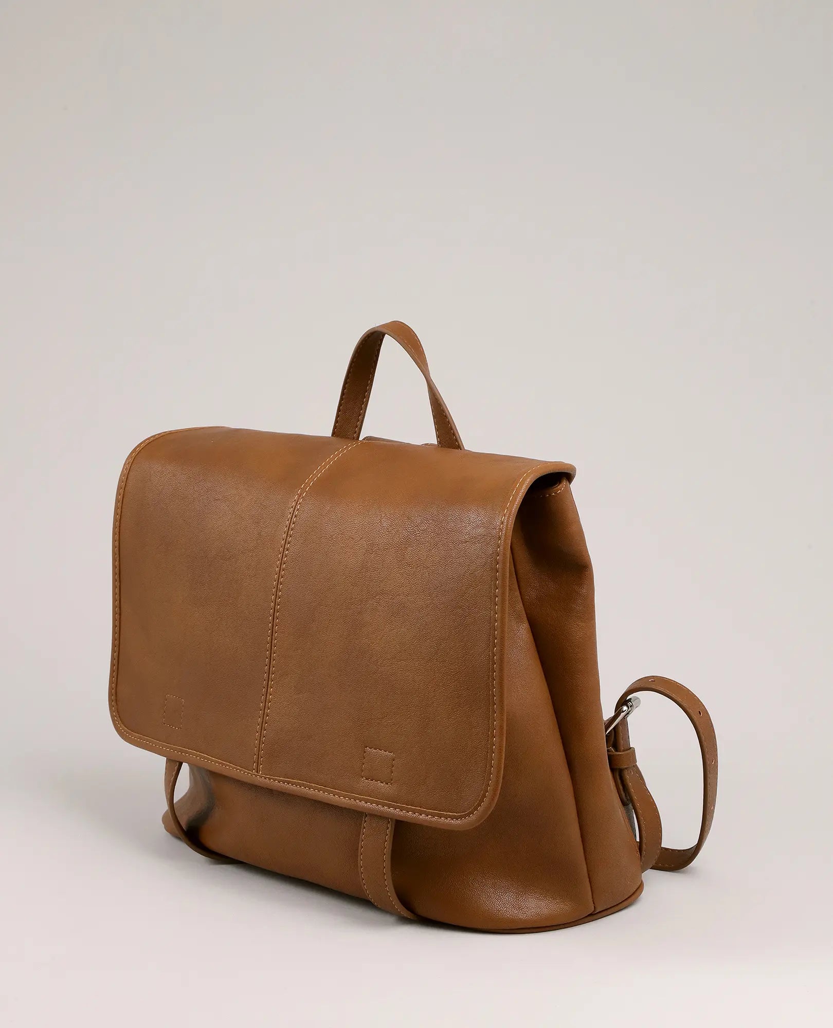 תיק גב-תיק בית ספר "נינה" מעור חום מבית B-Unique Bags, עם כיס קדמי, ידית עליונה ורצועות מתכווננות, מוצג על רקע ניטרלי.